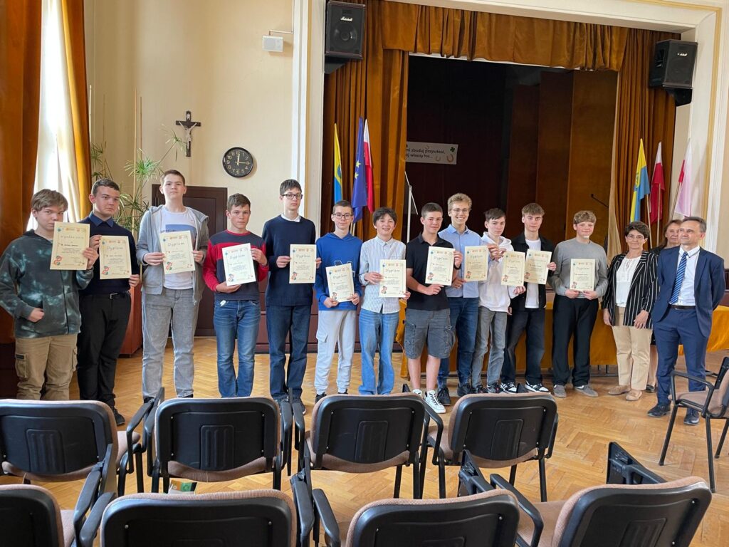 uczniowie nagrodzeni na tle sceny w szkolnej auli