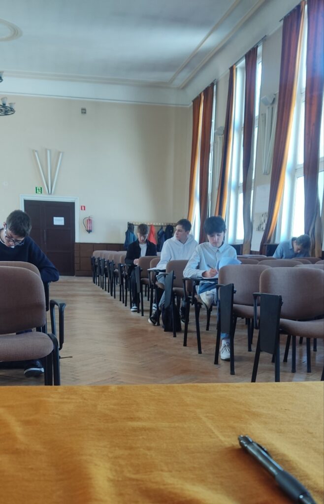 uczniowie piszący w sali test z chemii