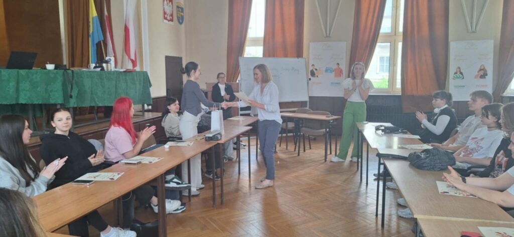aula szkoły, w niej uczniowie wykonujący rysunki o tematyce stop przemocy, ujęcie z prawej strony